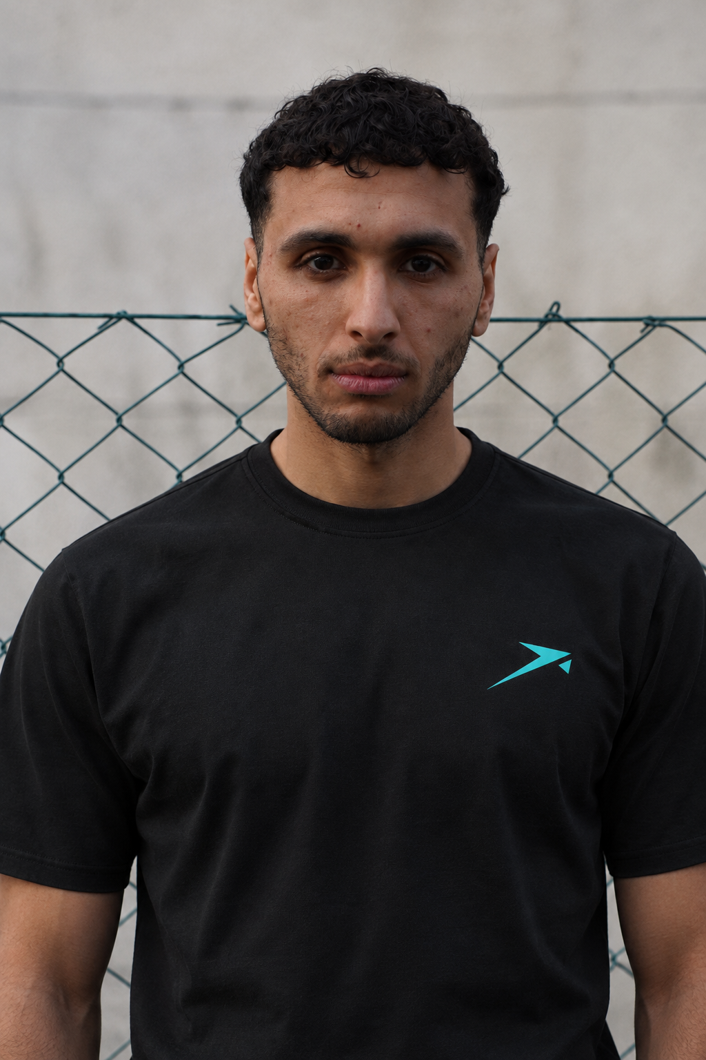 Urban portrait in the black Beldi Dept. Performance T-Shirt with aquamarine logo